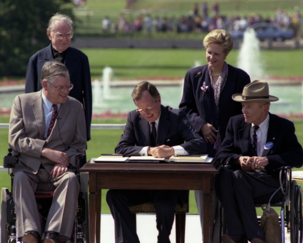 President Bush signs the Americans with Disabilities Act into law in front of the White House, July 26, 1990. Photo credit: Records of the White House Photograph Office