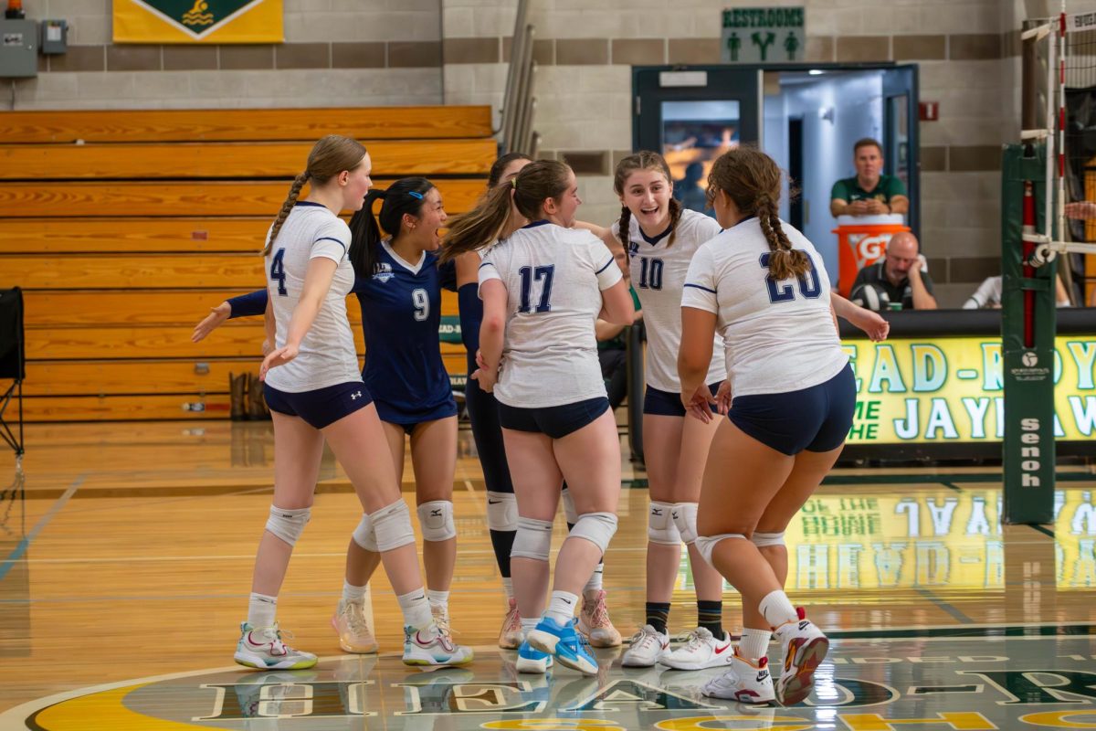 The girls' varsity volleyball team celebrating at a game against Head-Royce School on Sept. 27. Photo credit: Geoff Ruth.